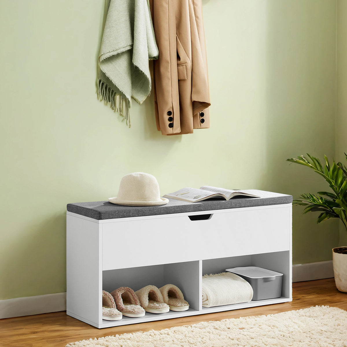 White shoe storage bench with gray cushion in an entryway