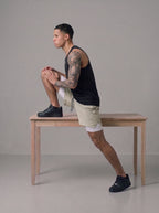 Men's 2-in-1 gym shorts in khaki with built-in liner, worn on bench